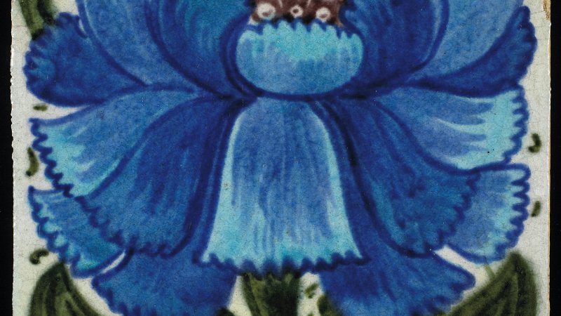 A tile of a blue flower and green stalk and leaves. There are many rectangular petals bursting forth. 