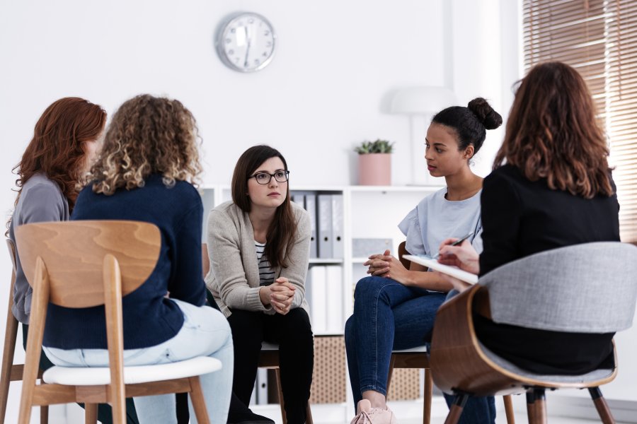 women supporting each other during psychotherapy group meeting