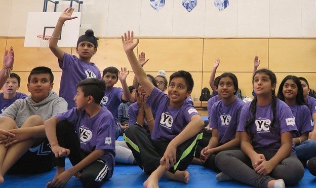 Youth taking part in the Yo Bro Yo Girl program, actively engaged inside a gymnasium.