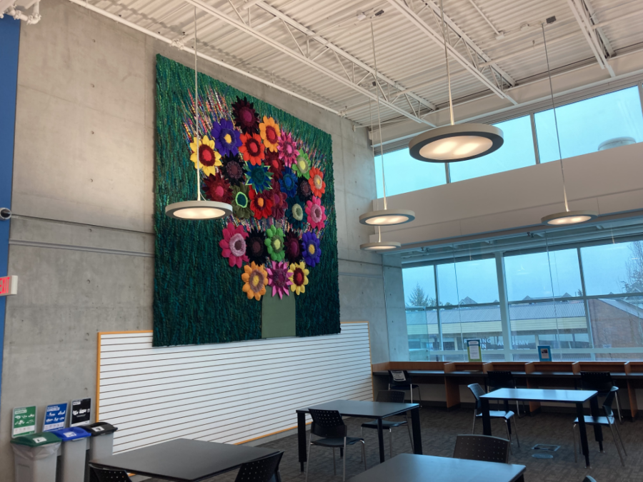 Photo of Flower Power by Sola Fiedler: Colourful tapestry depicting 3D flowers made from repurposed and recycled materials